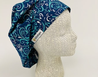 May include: A blue and white patterned scrub hat with a white label that says "KimKaps".