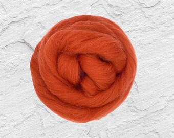 May include: A close-up of a ball of orange wool yarn. The yarn is soft and fluffy, and it is perfect for knitting or crocheting.