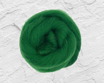 May include: A tightly wound ball of vibrant green wool roving, displayed against a textured white background. The wool appears soft and fluffy, ideal for various fiber art projects like needle felting or spinning. The bright green color is eye-catching.