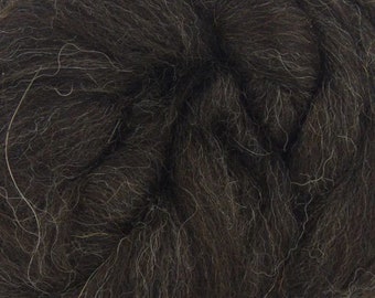 May include: Close-up of a dark brown wool roving. The wool is soft and fluffy, with a slightly textured appearance.