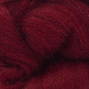 May include: A close-up of a deep red wool roving. The fibers are soft and fluffy, perfect for felting or spinning.