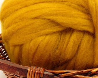May include: A large ball of golden yellow wool fibre in a wicker basket.