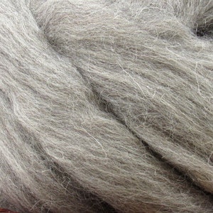 May include: A close-up of a bundle of light gray wool fibers. The wool is soft and fluffy, and it is perfect for spinning or felting.