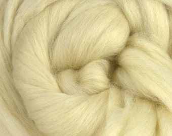 May include: Close-up of a mass of soft, creamy-yellow wool roving. The fibers are tightly packed and appear fluffy, with a slightly wavy texture. The wool is ideal for various fiber arts and crafts.
