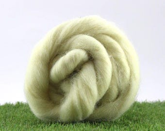 May include: A ball of light green wool roving, a type of fiber used for spinning yarn or felting.