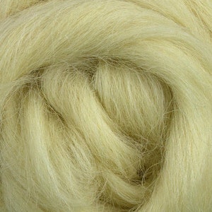 May include: Close-up of a mass of pale yellow wool roving. The fibers are soft and wavy, with a slightly textured appearance. The wool is tightly packed, creating a dense, yet airy, look. Ideal for various fiber art projects.