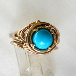 May include: A gold ring with a turquoise gemstone set in a delicate, intricate design.