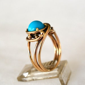 May include: A gold ring with a turquoise stone set in a twisted band.