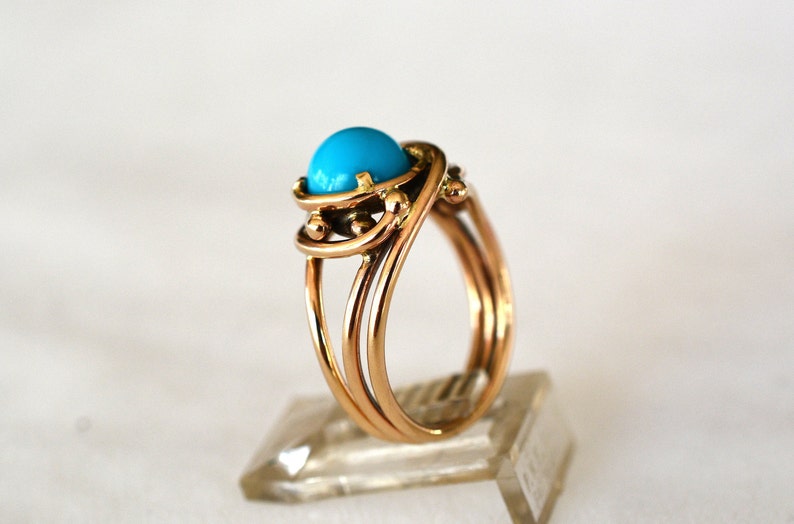 May include: A gold ring with a turquoise stone set in a twisted band.