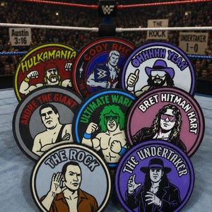 May include: A collection of eight circular embroidered patches featuring professional wrestlers including Hulk Hogan with the text HULKAMANIA, Cody Rhodes, Macho Man Randy Savage with OHHHHH YEAH, Andre the Giant, Ultimate Warrior, Bret Hitman Hart, The Rock, and The Undertaker.
