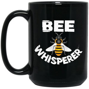 May include: Black coffee mug with a white bee graphic and the text "BEE WHISPERER".