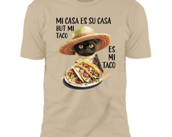 May include: A tan t-shirt with a black cat wearing a sombrero and holding three tacos. The text on the shirt reads "Mi casa es su casa but mi taco es mi taco".
