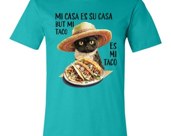 May include: A turquoise t-shirt with a black cat wearing a sombrero and holding three tacos. The text on the shirt reads "Mi casa es su casa but mi taco es mi taco".