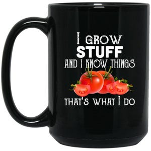 May include: Black ceramic mug with the text "I GROW STUFF AND I KNOW THINGS THAT'S WHAT I DO" in white. The mug features illustrations of whole and sliced red tomatoes, perfect for gardeners.