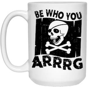 May include: White ceramic coffee mug with a black and white graphic of a skull and crossbones with the text "Be Who You Are Arrgg".