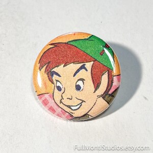 May include: A round button featuring a cartoon illustration of a character with red hair and a green hat. The button has a glossy finish and a colorful design, with the character's face prominently displayed. The button is a collectible item.
