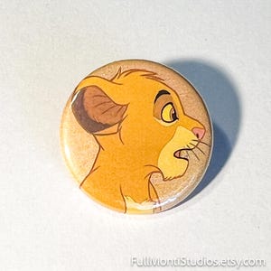 May include: A white ceramic mug with a black handle and the text "But First, Coffee" in a bold, black font. The mug is set against a blurred background, suggesting a cozy setting.