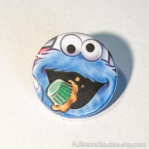 May include: A white ceramic mug with a black handle and the text "But First, Coffee" in a bold, black font. The mug is set against a neutral background, highlighting its simple design.