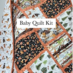 May include: A baby quilt kit featuring a woodland theme with various animals, trees, and mushrooms. The quilt is made of different fabrics with a variety of colors and patterns. The kit includes all the necessary materials to make a baby quilt.