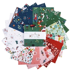 Pode incluir: Uma coleção de quadrados de tecido com tema natalino em várias cores, incluindo vermelho, verde e azul. O tecido apresenta desenhos festivos como quebra-nozes, presentes e personagens de férias. Um pacote quadrado central exibe o texto "Nutcracker Edition."