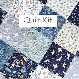 May include: A patchwork quilt featuring square fabric panels in shades of navy blue, light blue, and white. The fabric displays patterns of woodland animals, foliage, and stars. The text Quilt Kit is centered on a white rectangular overlay.