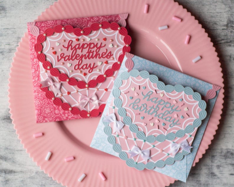 May include: Two handmade greeting cards with a heart-shaped design. The card on the left is red with white polka dots and says "happy valentine's day". The card on the right is blue with white polka dots and says "happy birthday".