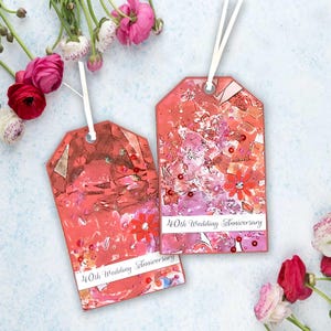 May include: Two rectangular gift tags with white ribbon loops, featuring a vibrant pink and red abstract watercolour design with scattered sequins and small flower cutouts. Each tag displays the printed text 40th Wedding Anniversary.