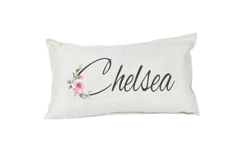 May include: A white pillow with a floral design and the name "Chelsea" printed in black cursive script.