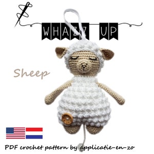 May include: A white crocheted sheep with a beige face and closed eyes. The sheep is a pull toy with a wooden button on its belly. The image includes the text "Whazz Up" and "Sheep".