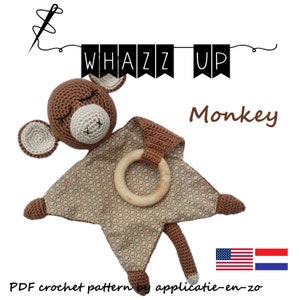 Op de afbeelding: Een gehaakt aapje speelgoed met een bruin en beige kleurenschema. De aap is bevestigd aan een bruin en groen gestreept dekentje met een houten bijtring. Het dekentje is een gehaakt vierkant met een afgeronde hoek. De afbeelding bevat de tekst "Whazz Up Monkey" en de tekst "PDF crochet pattern by applicatie-en-zo".