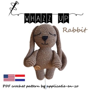 May include: A crochet pattern for a brown rabbit amigurumi toy. The pattern is called "Whazz Up Rabbit" and is available in English and Dutch. The pattern includes a flag of the United States and the Netherlands.