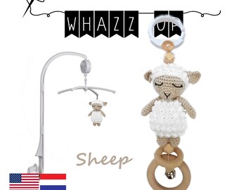May include: A crochet sheep baby mobile with a wooden ring and a bell. The mobile is hanging from a white metal stand. The mobile is labeled "Sheep" and "PDF crochet pattern by applicatie-en-zo".