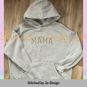 May include: Grey hooded sweatshirt with the word "MAMA" printed in orange on the front.