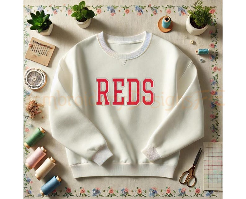 K&ouml;nnte beinhalten: Wei&szlig;er Pullover mit einem roten "REDS"-Logo auf der Vorderseite.