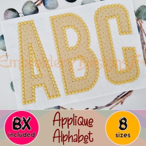 May include: A close-up of three embroidered letters, A, B, and C, in a beige color with a gold outline. The letters are on a white background. The letters are part of an applique alphabet set that includes 8 sizes.