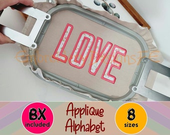 Puede incluir: Letras bordadas en aplique que deletrean "LOVE" en rosa con un patrón floral sobre una tela beige. Las letras están en una fuente en negrita y de bloque. La tela está en un aro de bordado. La imagen incluye el texto "Applique Alphabet" y "8 tamaños".