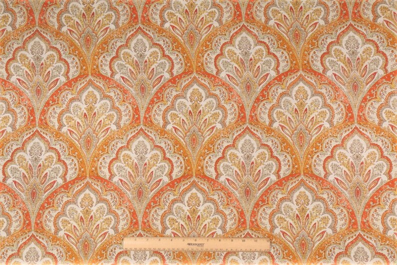May include: Orange, yellow, and gray paisley patterned fabric with a repeating design. The fabric has a subtle sheen.