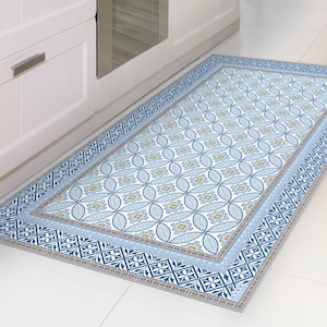 May include: A rectangular kitchen mat with a blue and white floral pattern. The mat has a blue border with geometric designs and is placed in front of a white cabinet. The mat's dimensions are approximately 24 inches wide and 60 inches long.