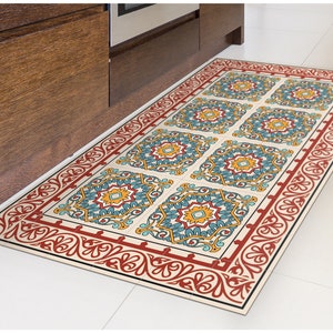 May include: A rectangular patterned rug with a red, white, and blue design. The rug has a decorative border with a floral pattern.