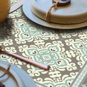 May include: A decorative table runner with a repeating pattern of blue, white, and brown geometric shapes. The runner is made of a durable material and is perfect for adding a touch of style to any dining table.