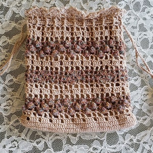 Monedero de crochet, bolso grande tipo muñequera. Bolso de tamaño perfecto hecho a mano de 7,5" x 6" con borlas. Beige y oro rosa con hilo metálico turquesa texturizado.