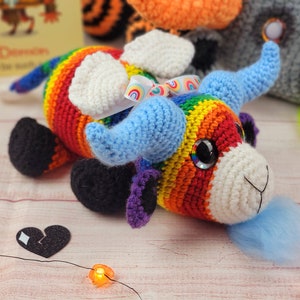 Peut inclure: Un jouet de taureau crochet&eacute; &agrave; la main aux couleurs de l'arc-en-ciel. Le taureau a des cornes bleues, des oreilles blanches et des sabots noirs. Il a un museau blanc et de grands yeux brillants. Un petit ruban arc-en-ciel est nou&eacute; sur sa t&ecirc;te. Fait main.