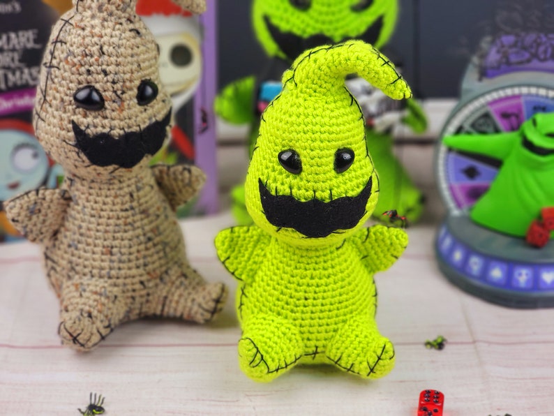 Puede incluir: Dos personajes de Pesadilla Antes de Navidad hechos a crochet. Uno es verde con una boca cosida negra y ojos negros. El otro es marr&oacute;n claro con una boca cosida negra y ojos negros.