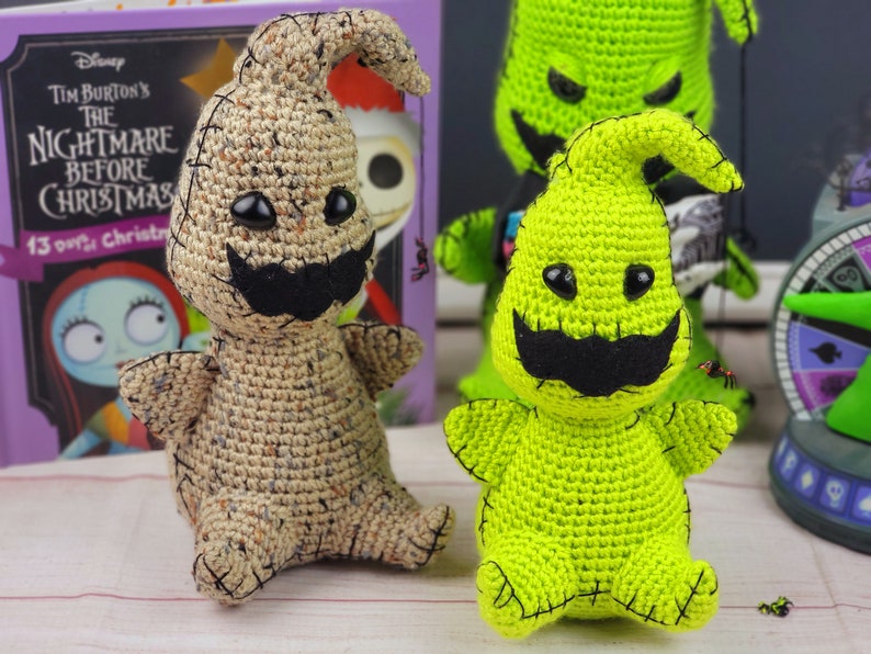 Puede incluir: Dos peluches de crochet del personaje 'Oogie Boogie' de la pel&iacute;cula 'Pesadilla antes de Navidad'. Uno es beige y el otro es verde. Ambos tienen ojos negros y un bigote negro.