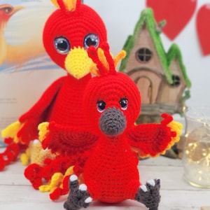 Peut inclure: Deux oiseaux phénix rouges en crochet avec des accents jaunes. Le plus grand phénix a une longue queue bouclée. Le plus petit phénix a les ailes déployées.