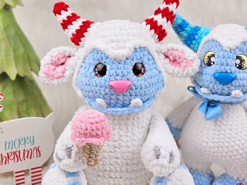 Pu&ograve; includere: Due giocattoli di peluche all'uncinetto, uno blu e bianco con un cono gelato rosa, l'altro bianco con accenti blu. Entrambi hanno occhi grandi e un'espressione amichevole.