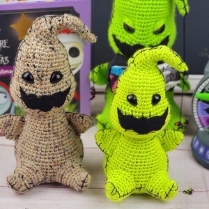 Puede incluir: Dos peluches de crochet del personaje 'El Fantasma Sin Nombre' de la pel&iacute;cula 'Pesadilla Antes de Navidad'. Uno es beige con ojos marrones y un bigote negro. El otro es verde con ojos negros y un bigote negro.