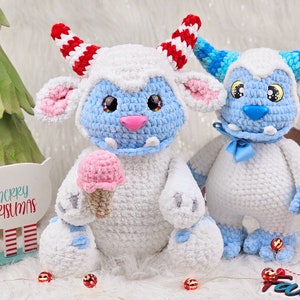 Pu&ograve; includere: Due peluche Yeti all'uncinetto, uno tiene un cono gelato rosa. Lo Yeti a sinistra ha corna a strisce rosso e bianco e pelliccia blu. Lo Yeti a destra ha corna a strisce blu e verdi e un fiocco blu.