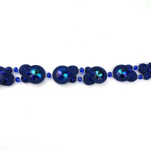 Peut inclure: Un bracelet bleu marine avec des cristaux bleus iris&eacute;s et des accents dor&eacute;s.