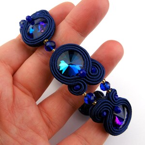 Peut inclure: Un bracelet bleu marine avec un cristal bleu fonc&eacute; et des perles bleues plus petites. Le bracelet est r&eacute;alis&eacute; avec une technique de cordon tress&eacute;.